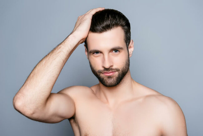 Come funziona la tecnica FUE Ragazzo si passa le mani tra i capelli