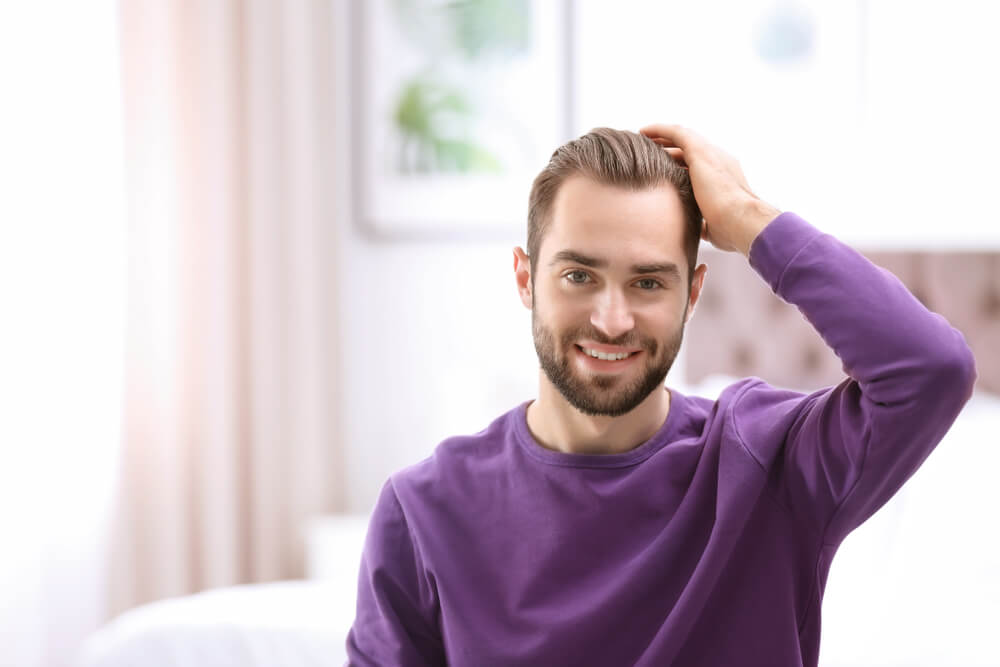 trapianto-fue-protesi ragazzo che si tocca i capelli